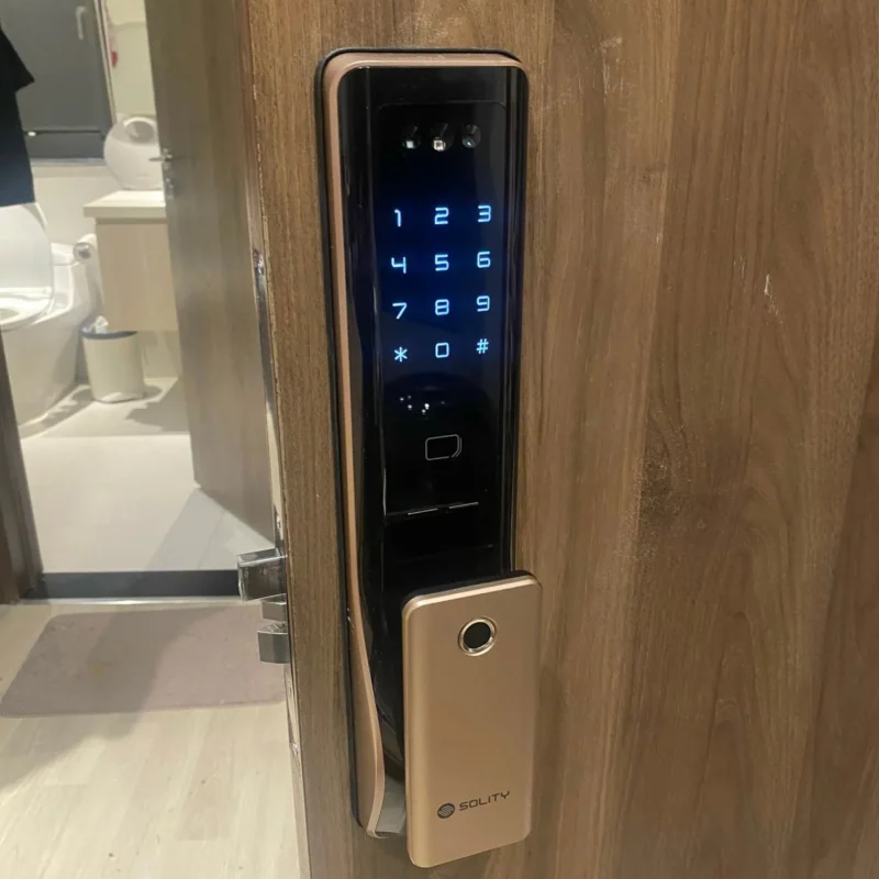 Bàn phím cảm ứng khóa Solity sáng trên cửa gỗ, hiển thị các số và phím sao, thăng.