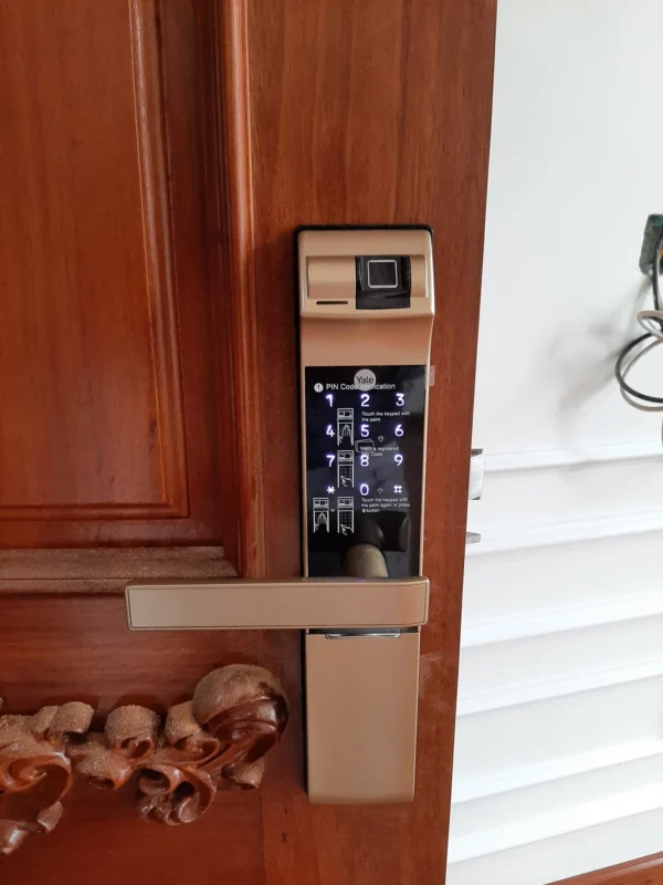 Khóa Yale YDM7116A màu vàng trên cửa gỗ với bàn phím cảm ứng đang sáng